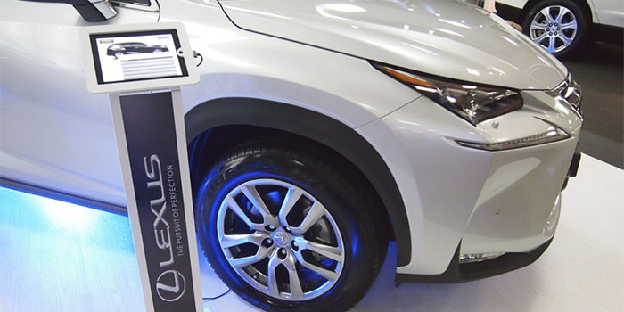 A tablet stand next to a Lexus